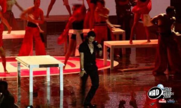 Καλλιτέχνης σε σκηνή με χορευτές και τραπέζια στα MAD Video Music Awards 2008.