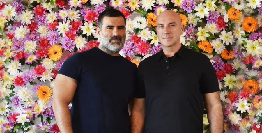 Οι Deux Hommes μπροστά από έναν τοίχο με λουλούδια.