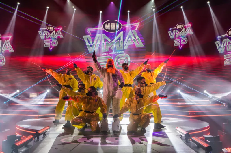 Καλλιτέχνες στη σκηνή των Mad Video Music Awards 2020 με κίτρινες στολές προστασίας.