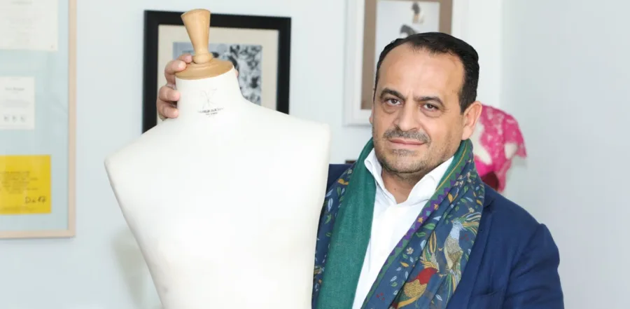 Ο Vassilis Zoulias δίπλα σε ένα λευκό μανεκέν ραπτικής.
