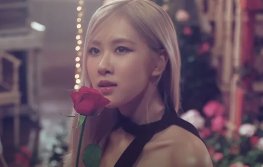 Η Rose των BLACKPINK κρατά ένα κόκκινο τριαντάφυλλο.