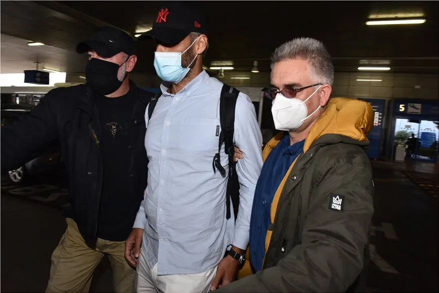 Ο Αλέξης Παππάς στο αεροδρόμιο συνοδευόμενος από δύο άνδρες.