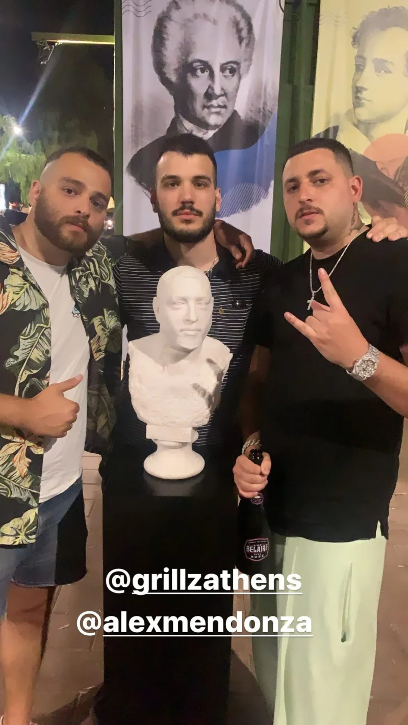 Ο Mad Clip με δύο φίλους του δίπλα σε μια λευκή προτομή του.