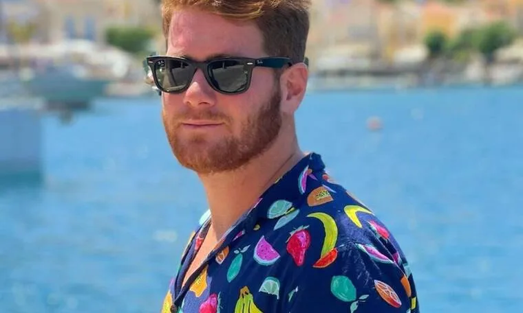 Ο James Καφετζής με γυαλιά ηλίου και πουκάμισο με φρούτα.