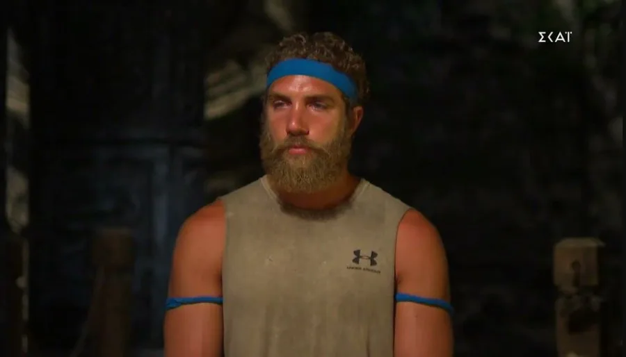Ο Γιώργος Κορόμι στο Survivor με μπλε κορδέλα και μούσια.