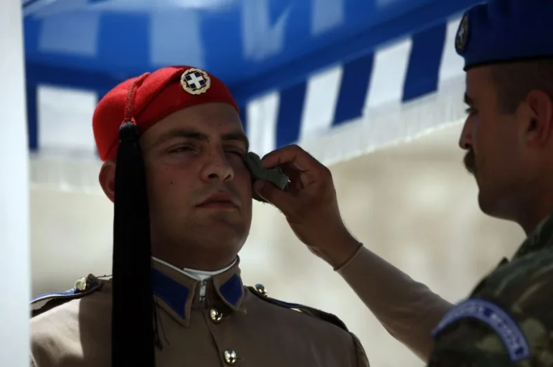 Εύζωνας της Προεδρικής Φρουράς δέχεται φροντίδα από στρατιωτικό κατά τη διάρκεια καύσωνα.