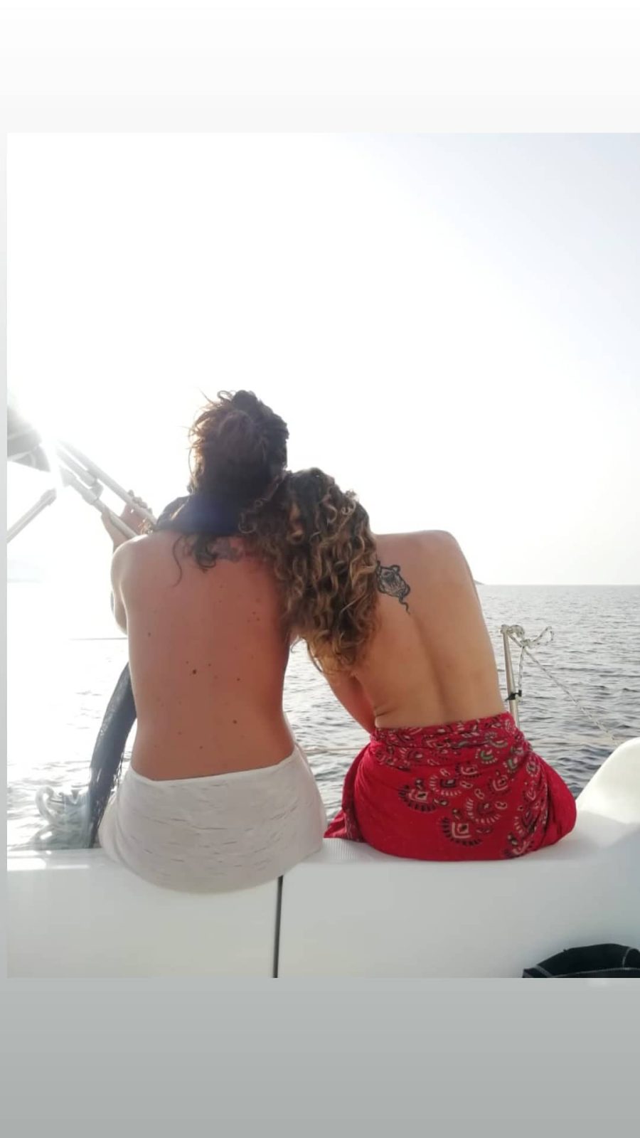 Η Έλλη Τρίγγου και μία φίλη της ποζάρουν topless στην πρύμνη ενός σκάφους στη θάλασσα.