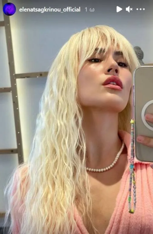 Η Έλενα Τσαγκρινού σε selfie με ξανθά κυματιστά μαλλιά και ροζ ζακέτα.