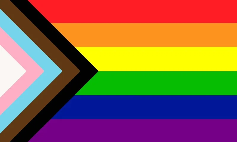Η σημαία Progress Pride με τα χρώματα του ουράνιου τόξου και επιπλέον λωρίδες στα αριστερά.