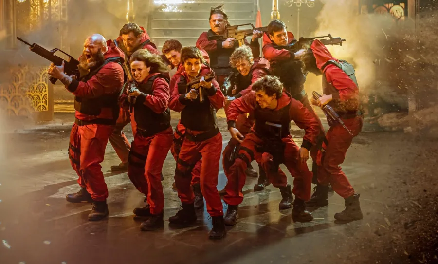Σκηνή δράσης από τη σειρά La Casa de Papel με τους πρωταγωνιστές σε κόκκινες στολές.