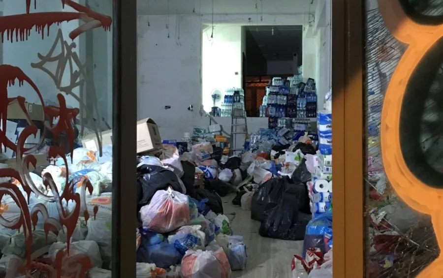 Εσωτερικός χώρος με συγκεντρωμένα είδη πρώτης ανάγκης και σακούλες για πυρόπληκτους.