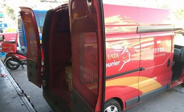 Κόκκινο βαν της ΕΛΤΑ Courier με ανοιχτές τις πίσω πόρτες.