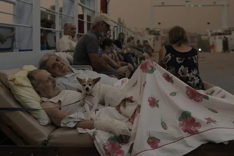 Ο Γεώργιος Λιάκος και η Παρισσώ Λιάκου με το σκυλάκι τους σε πλοίο κατά τη διάρκεια εκκένωσης.