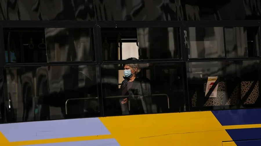 Επιβάτης με προστατευτική μάσκα μέσα σε λεωφορείο.