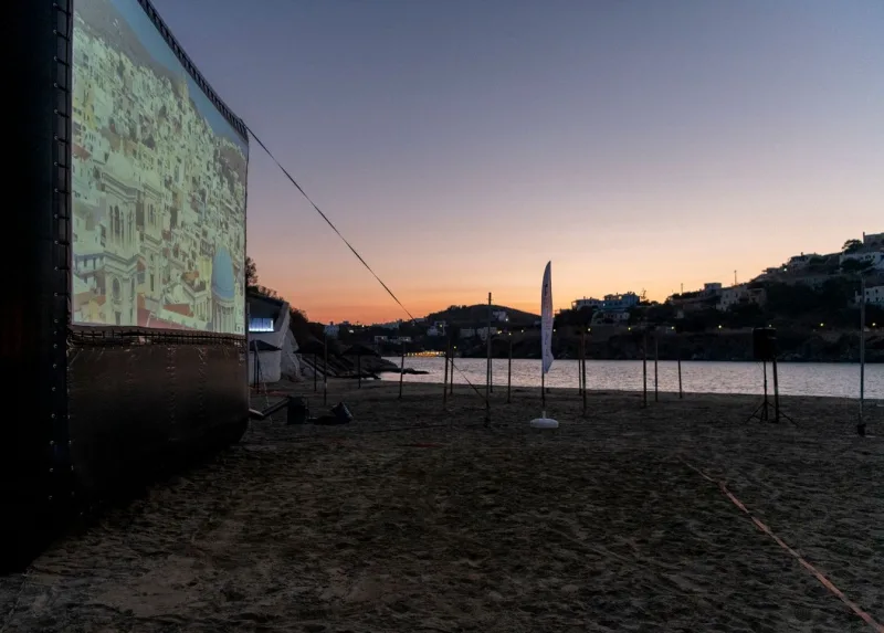 Υπαίθρια προβολή του Animasyros 2021 σε παραλία κατά το ηλιοβασίλεμα.