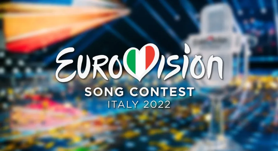 Το λογότυπο της Eurovision 2022 στην Ιταλία σε θολό φόντο σκηνής.
