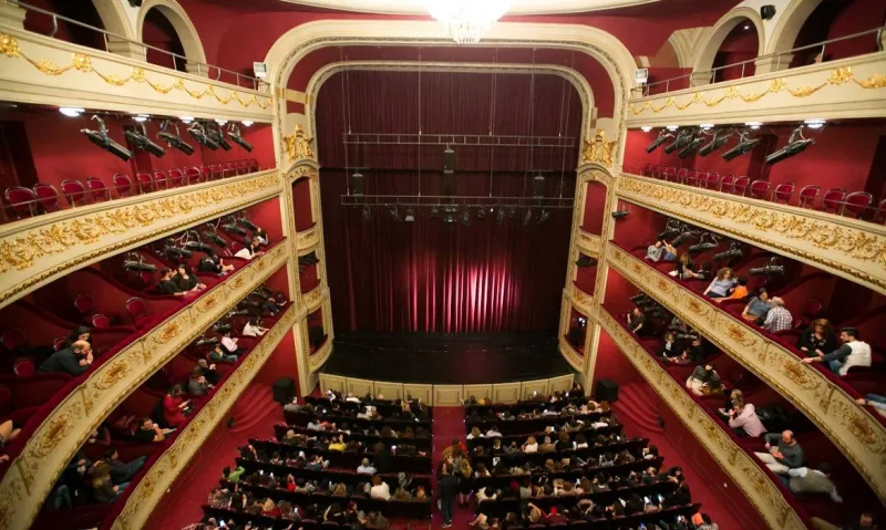 Εσωτερικό ιστορικού θεάτρου με θεατές στις κερκίδες και τα θεωρεία.