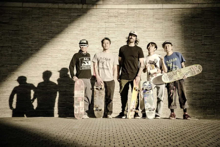 Πέντε άνδρες με skateboards μπροστά από τοίχο