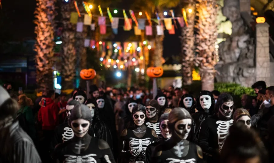 Παρέλαση Halloween στο Allou! Fun Park με άτομα ντυμένα σκελετούς.