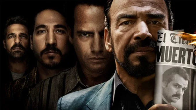 Τέσσερις άνδρες από τη σειρά Narcos κοιτάζουν την κάμερα, με τον έναν να κρατά μια φλεγόμενη εφημερίδα.