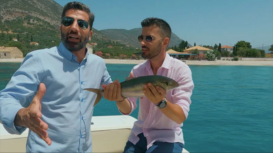 Ο Θανάσης Βισκαδουράκης και ο Γιάννης Τσιμιτσέλης σε σκάφος κρατώντας ένα ψάρι.