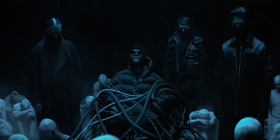 Ο The Weeknd και οι Swedish House Mafia σε σκοτεινό σκηνικό από το βίντεο κλιπ Moth To A Flame.