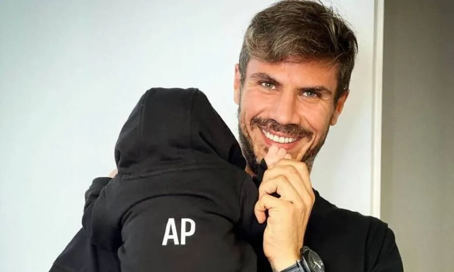 Ο Άκης Πετρετζίκης κρατάει στην αγκαλιά του τον γιο του.