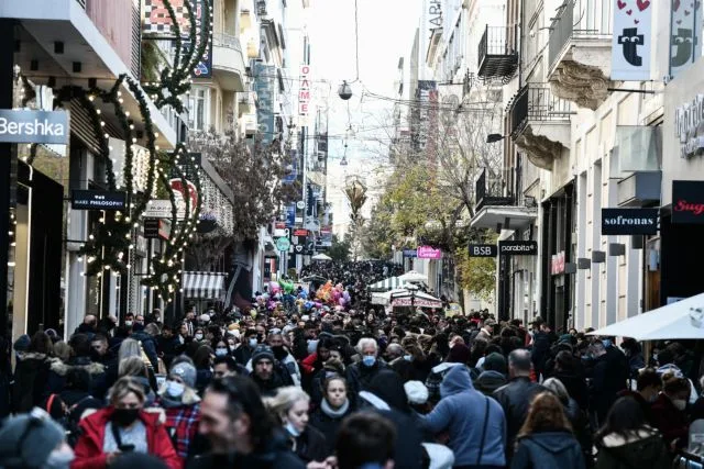 Καταναλωτές στην οδό Ερμού για χριστουγεννιάτικες αγορές κατά τη διάρκεια εφαρμογής νέων μέτρων προστασίας.