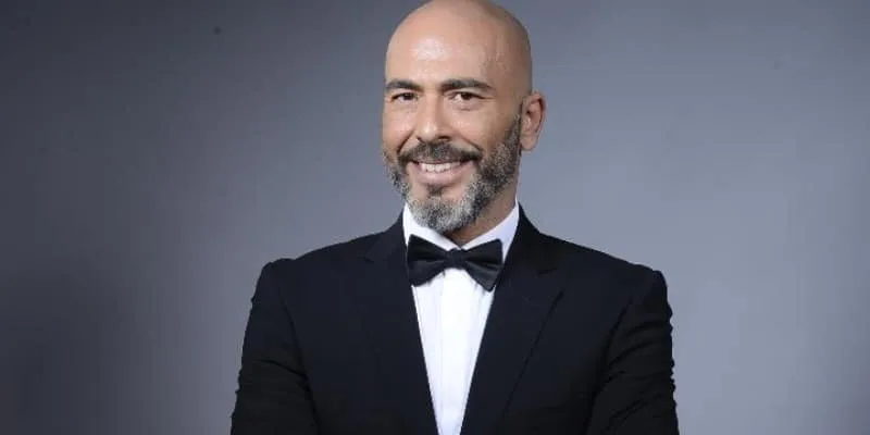Άνδρας με κοστούμι και παπιγιόν σε γκρι φόντο