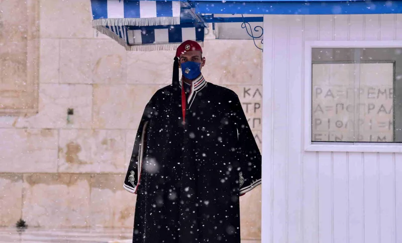 Εύζωνας με τη χειμερινή ενδυμασία του στο Σύνταγμα κατά τη διάρκεια χιονόπτωσης.