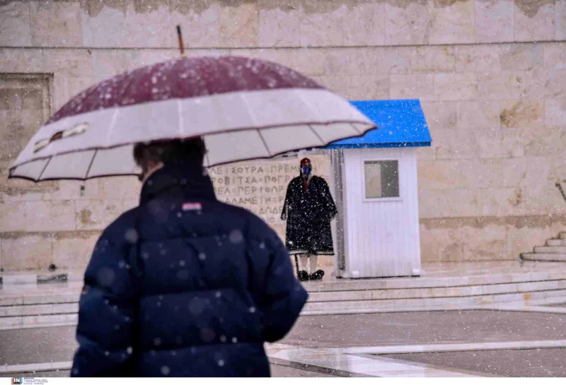 Εύζωνας με χειμερινή ενδυμασία στο μνημείο του Άγνωστου Στρατιώτη κατά τη διάρκεια χιονόπτωσης.