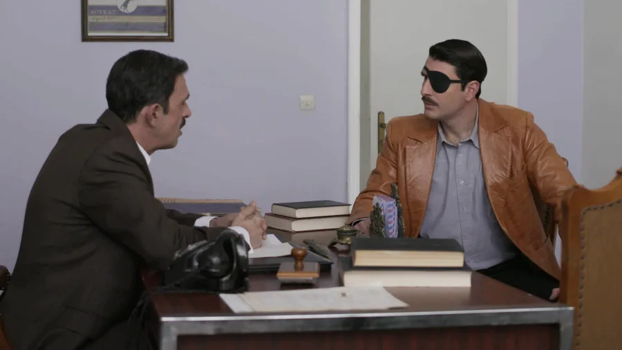 Ο Μελέτης σε γραφείο με έναν άνδρα στη σειρά Άγριες Μέλισσες.