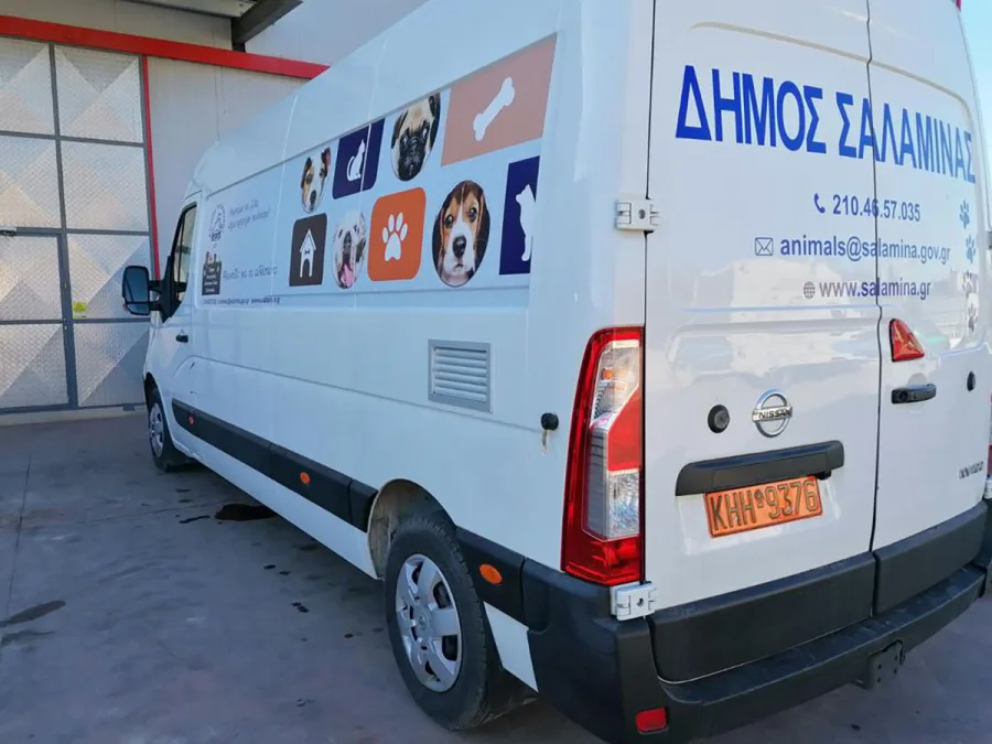 Λευκό ασθενοφόρο του Δήμου Σαλαμίνας για αδέσποτα ζώα με αυτοκόλλητα σκύλων και γατών.
