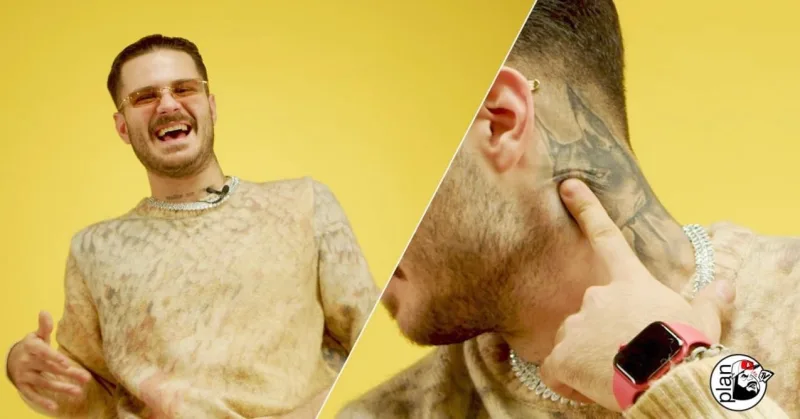 Ο GetRich γελάει και δείχνει το τατουάζ στον λαιμό του.