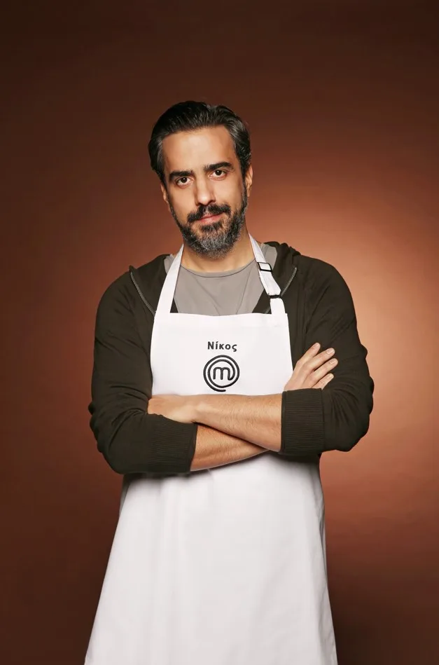 Ο Νίκος, ένας από τους 24 παίκτες του MasterChef, ποζάρει με ποδιά του παιχνιδιού.