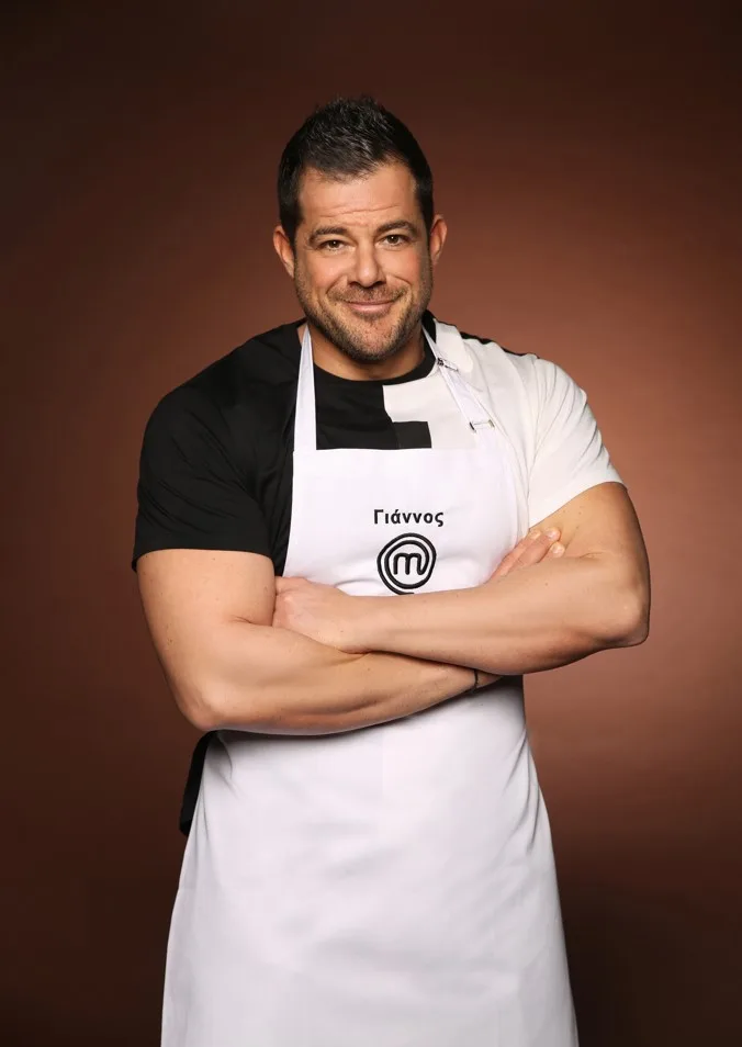 Ο Γιάννος, ένας από τους 24 παίκτες του MasterChef, ποζάρει με ποδιά και χαμόγελο στο σπίτι του παιχνιδιού.