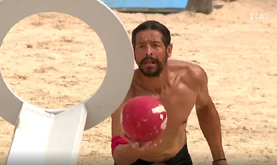 Ο Απόστολος Ρουβάς σε αγώνισμα του Survivor κρατώντας μια κόκκινη μπάλα.