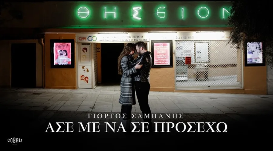 Ο Γιώργος Σαμπάνης αγκαλιά με μια γυναίκα έξω από τον κινηματογράφο Θησείον.