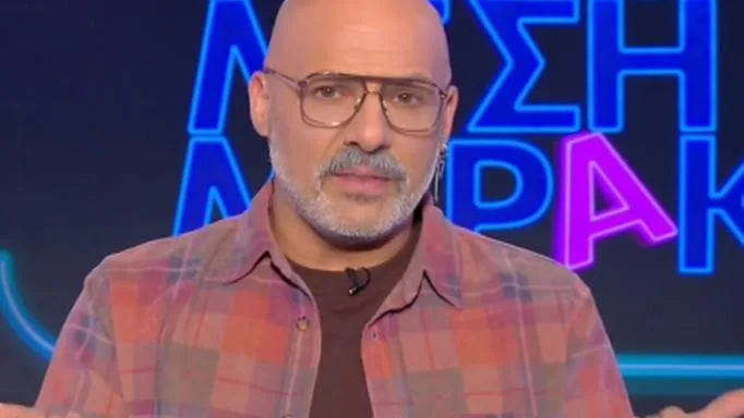 Ο Νίκος Μουτσινάς με γυαλιά και καρό πουκάμισο στο πλατό της εκπομπής Καλό Μεσημεράκι.