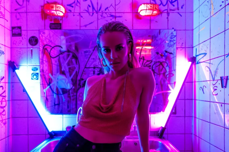 Η Ιλένια Williams σε σκηνικό με neon φωτισμό και γκράφιτι.