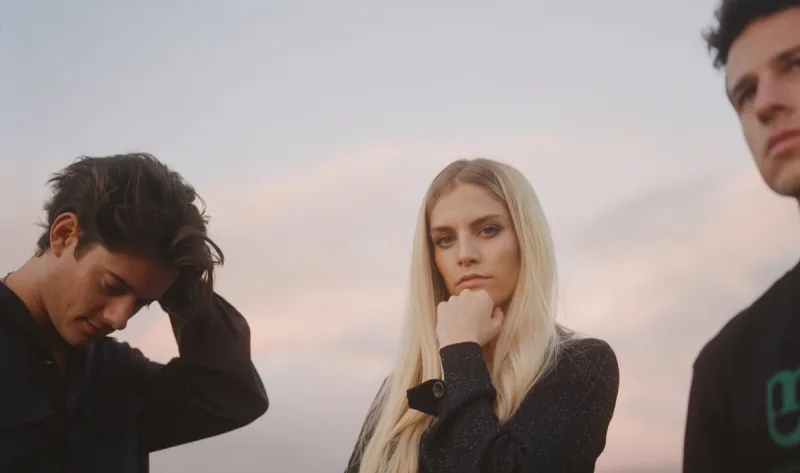 Το συγκρότημα London Grammar σε εξωτερικό χώρο με φόντο τον ουρανό.