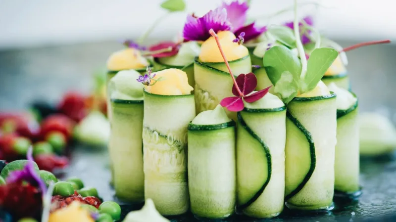 Vegan πιάτο με ρολά αγγουριού και βρώσιμα άνθη.