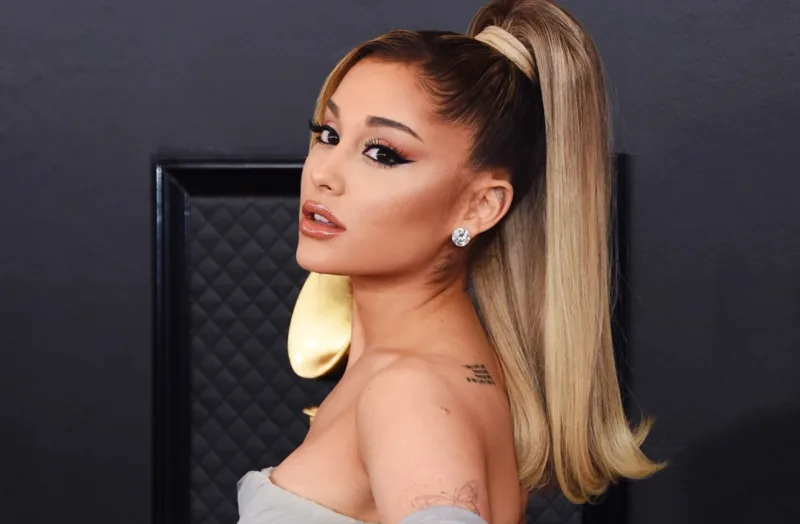 Η Ariana Grande με ψηλή αλογοουρά και γκρι φόρεμα σε γκαλά.