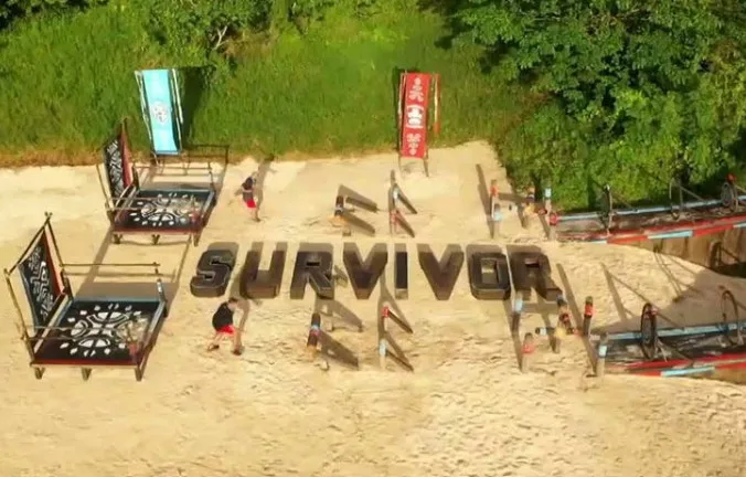 Στίβος μάχης του Survivor με παίκτες και εμπόδια στην άμμο.