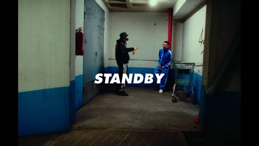 Ο Bloody Hawk και ο Dani Gambino σε εσωτερικό χώρο με τη λέξη STANDBY.