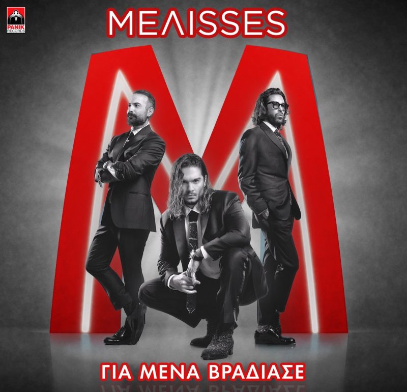 Το συγκρότημα ΜΕΛΙΣΣΕΣ με μαύρα κοστούμια μπροστά από ένα κόκκινο γράμμα Μ.