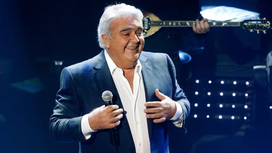 Ο Πασχάλης Τερζής τραγουδάει στη σκηνή κρατώντας μικρόφωνο.