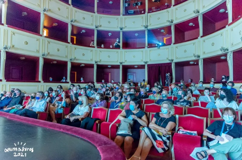 Κοινό με μάσκες προστασίας παρακολουθεί προβολή στο Animasyros.