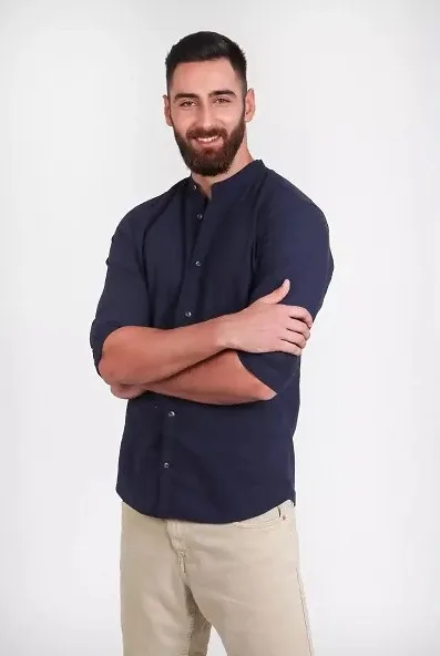 Παίκτης του Love Island με μπλε πουκάμισο και μπεζ παντελόνι.