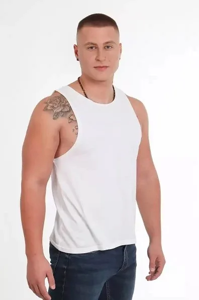 Άνδρας παίκτης του Love Island με λευκό φανελάκι και τατουάζ στον ώμο.